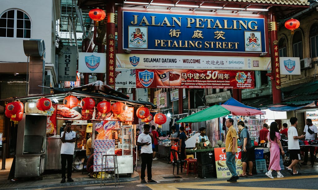 A bustling scene at Petaling Street in Kuala Lumpur featuring colorful stalls, vendors, and visitors.