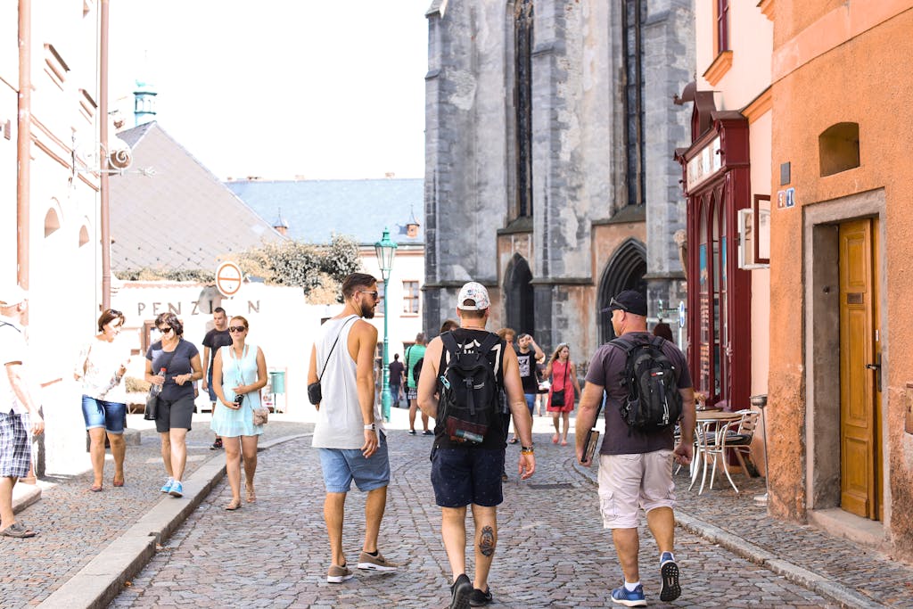 A bustling stone road in a historic European city filled with tourists enjoying a summer day.