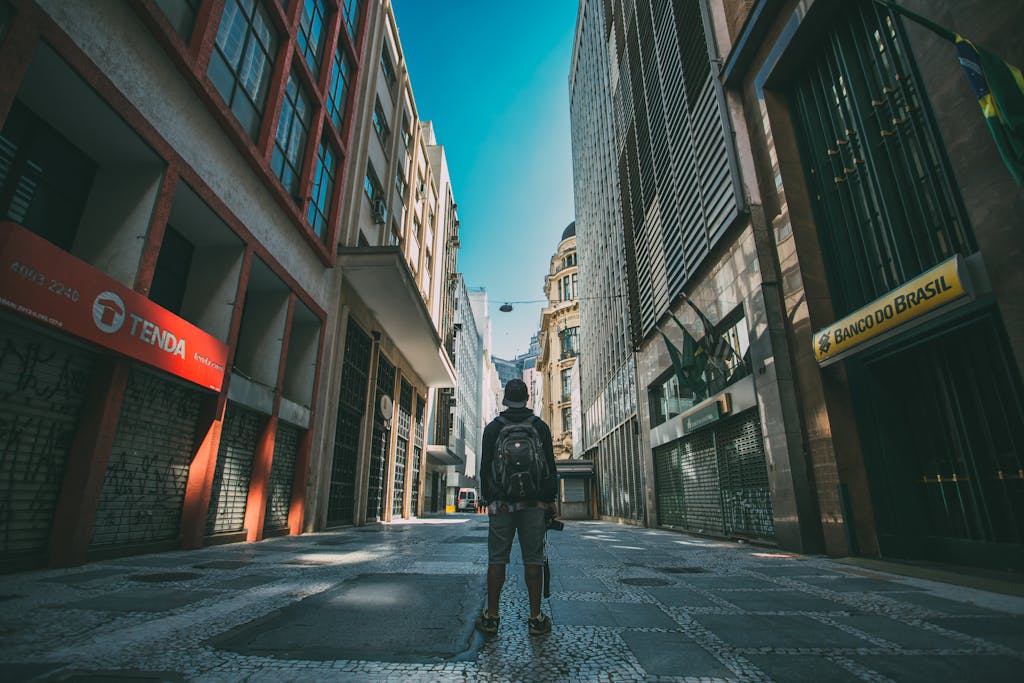 Man exploring São Paulo streets, vibrant urban atmosphere with towering buildings.
