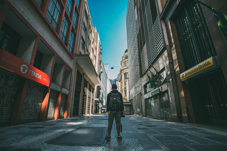 Man exploring São Paulo streets, vibrant urban atmosphere with towering buildings.