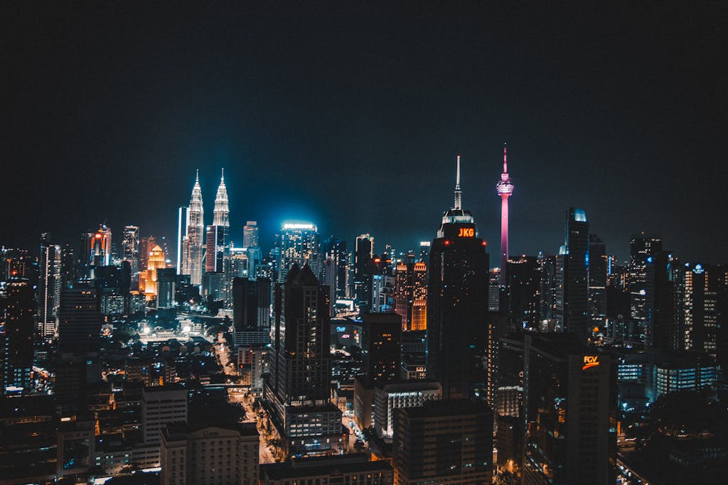 Stunning night view of Kuala Lumpur skyline featuring iconic towers and vibrant city lights.