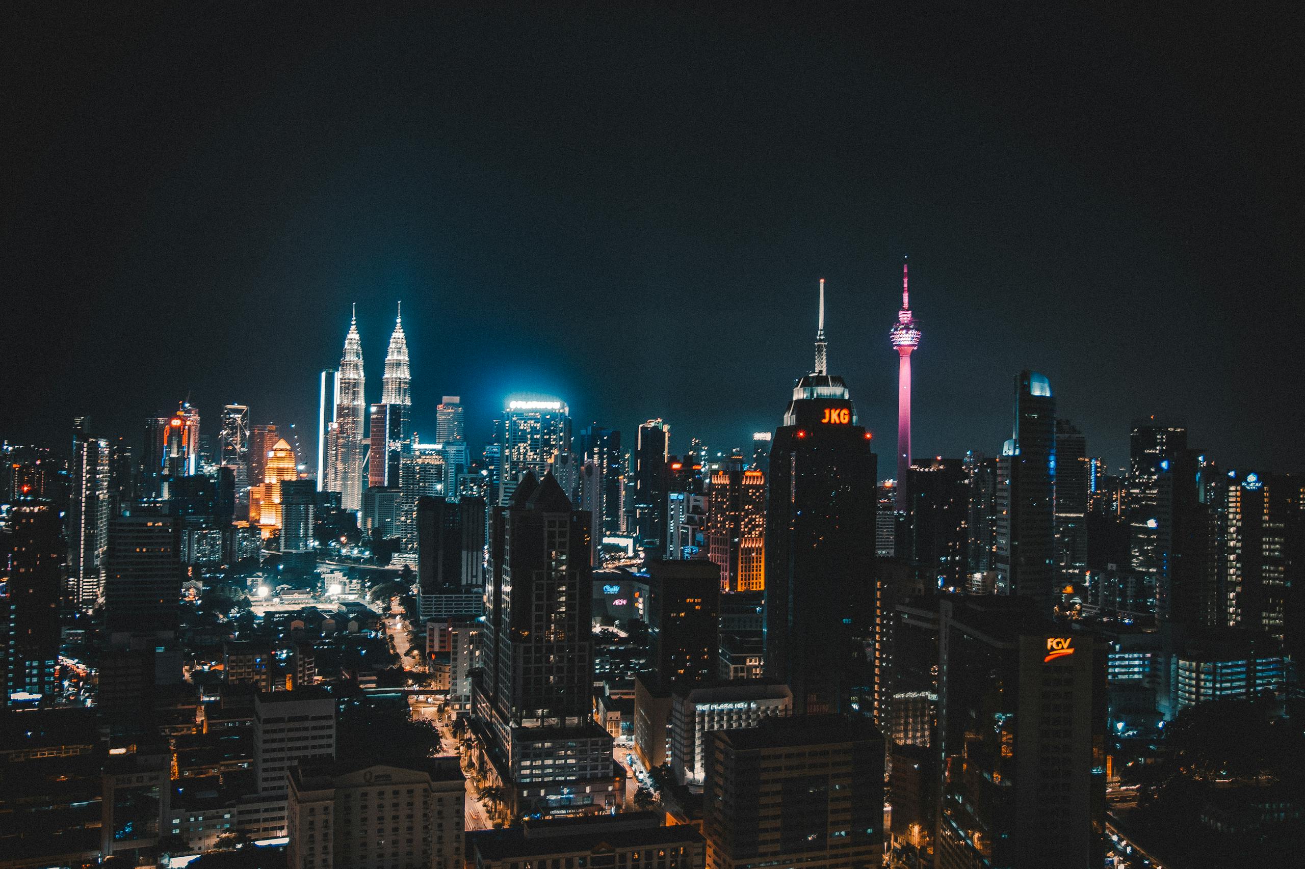 Stunning night view of Kuala Lumpur skyline featuring iconic towers and vibrant city lights.