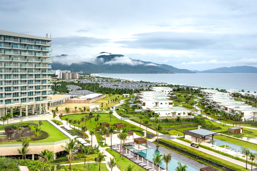 Aerial shot of a coastal resort with lush greenery and ocean view, perfect for summer vacations.