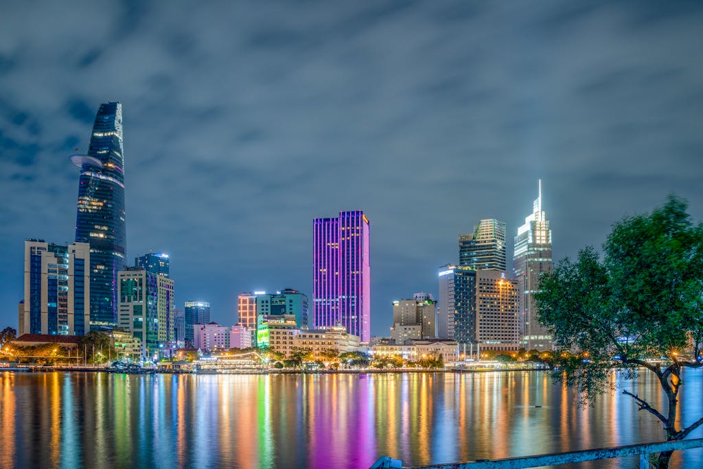 Stunning view of Ho Chi Minh City's illuminated skyline at night with reflections on the river.